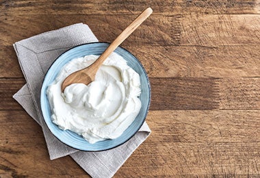  Yogurt con cuchara de madera, uno de los sustitutos del huevo.