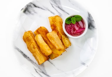 Porción de yuca frita para acompañar el chicarrón en receta de cocina fácil.