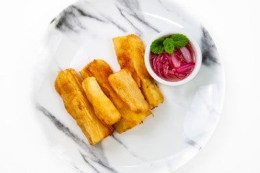 Yucas fritas con un acompañamiento de vegetales.