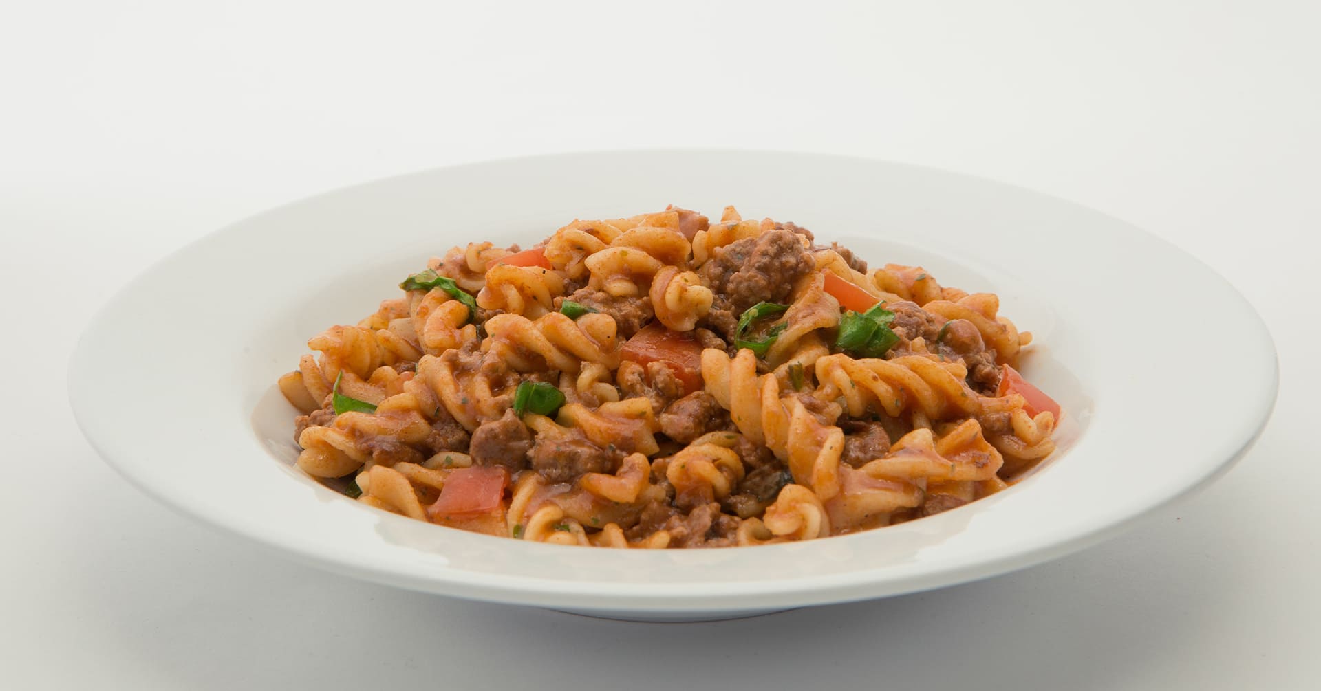 Tornillo de bolognesa con trozos de tomate y albahaca