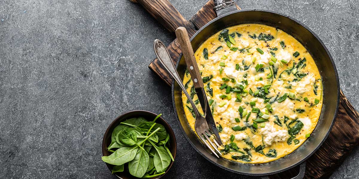 Huevos revueltos y espinaca cremosa sobre arepa