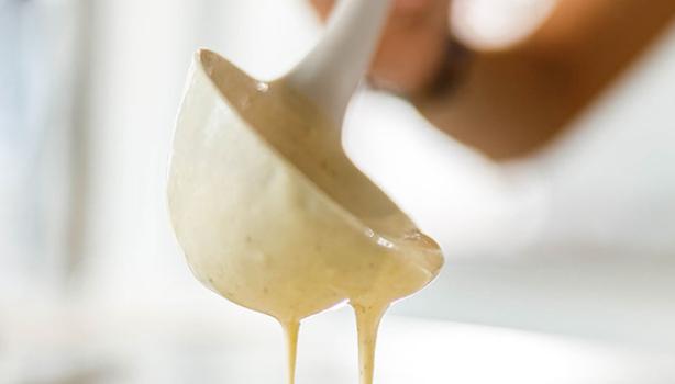 Una mujer preparando pancakes con un cucharón