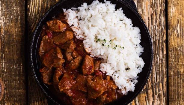 Carne en cuadros y arroz blanco en una sartén de hierro