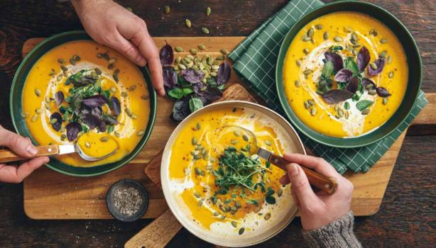 Tres tazones de sopa fría decorados con hierbas frescas 