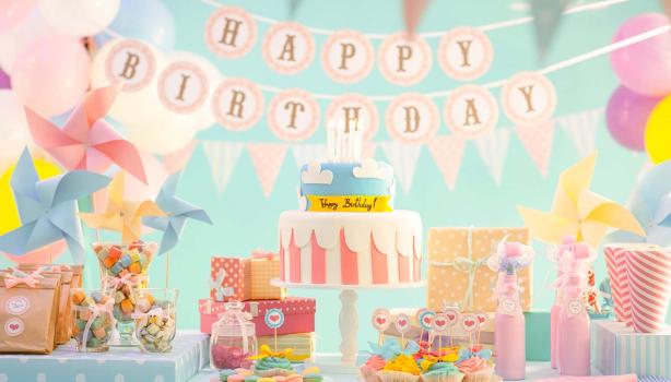 Celebración de cumpleaños con variedad de postres en una mesa de dulces