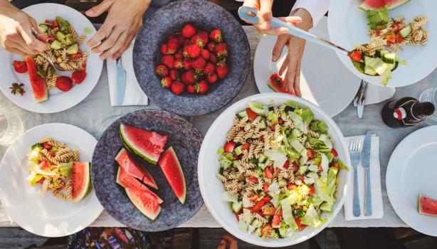 Mesa de picnic con ensalada con pasta y frutas