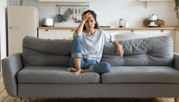  Una mujer aprendiendo a manejar el estrés en un sofá