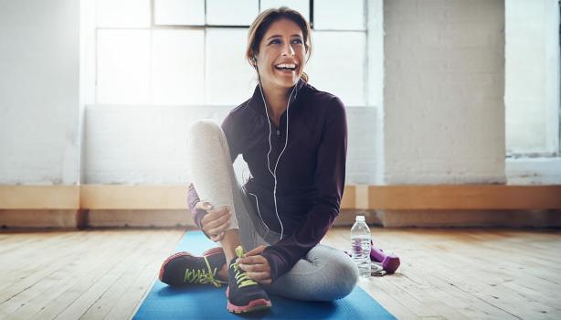 Una mujer preparándose para hacer deportes populares en su casa