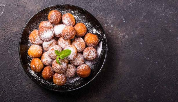 Plato de buñuelos de yuca espolvoreados vistos desde un ángulo cenital.