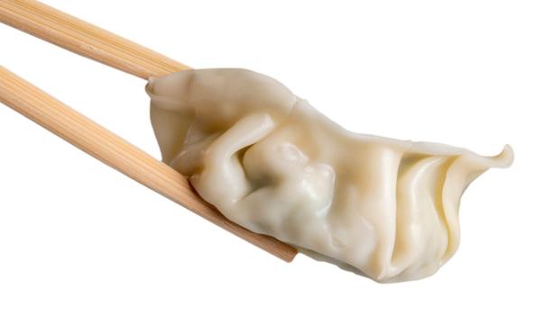 Gyoza de camarón tomada con palillos.