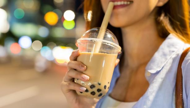 Mujer disfrutando de una bebida complementada con perlas de tapioca.