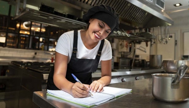 Cocinera anotando ideas para implementar en la cocina creativa.
