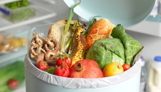 Caneca llena de desperdicios de alimentos vegetales.