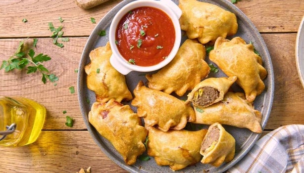Bandeja de empanadas con ají como entrada de comida para fiesta.
