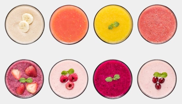 Ocho vasos llenos de smoothies de distintas frutas vistas desde arriba.