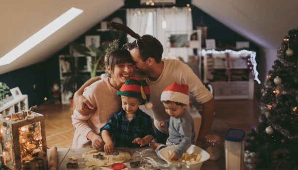 Familia reunida cocinando galletas durante una novena de Navidad para niños.