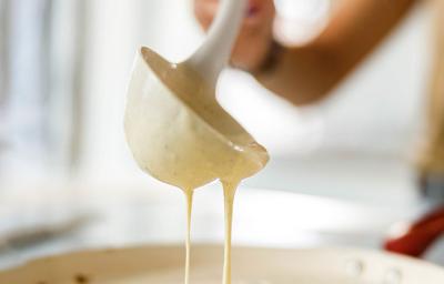 Una mujer preparando pancakes con un cucharón Una mujer preparando pancakes con un cucharón