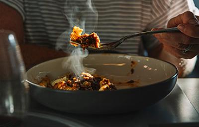 Una persona comiendo un plato de pasta, una de las comidas fáciles de hacer. Una persona comiendo un plato de pasta, una de las comidas fáciles de hacer.
