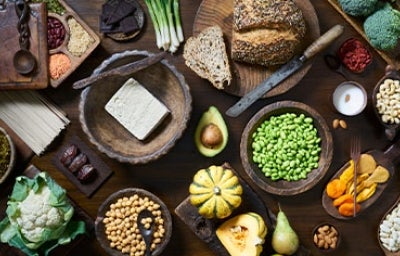 Tofu, granos, semillas y verduras servidas en una mesa, comidas veganas que se suelen usar