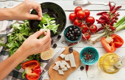 Aceite de oliva, queso, frutas cítricas y tomates para una ensalada griega, una comida mediterránea.