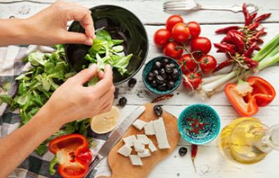 Las ensaladas navideñas suelen ser coloridas. Una persona preparando una ensalada navideña, deliciosa y colorida.