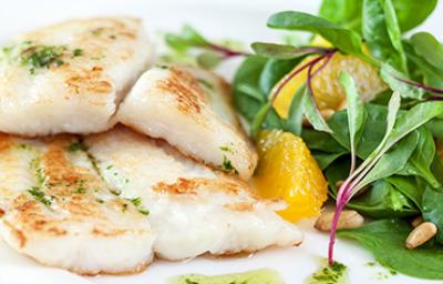 Pescado preparado en freidora de aire con una ensalada de hojas verdes.