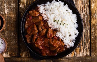 Carne en cuadros y arroz blanco en una sartén de hierro