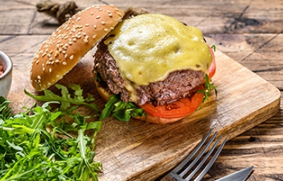 Hamburguesa de queso abierta con cubiertos