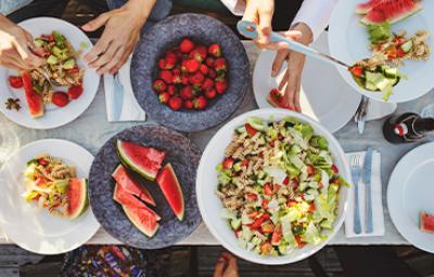 Mesa de picnic con ensalada con pasta y frutas