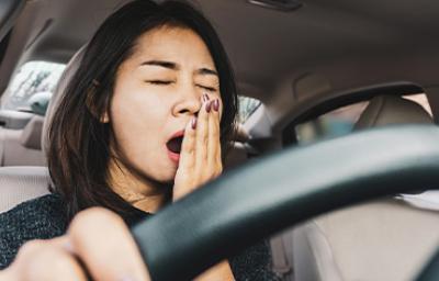Una mujer bostezando, pensando en cómo dejar de procrastinar Una mujer bostezando, pensando en cómo dejar de procrastinar