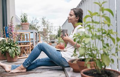 Una mujer con un vaso y un plato de comida aprovechando un buen descanso