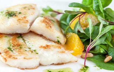 Pescado a la plancha con una ensalada fresca y pequeños brotes Pescado a la plancha con una ensalada fresca y pequeños brotes