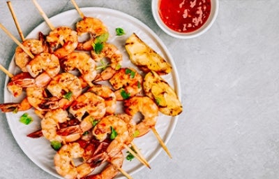 Camarones y langostinos al ajillo, tipos de mariscos en pincho con salsa