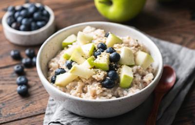 Plato de porridge con arándanos y manzana verde