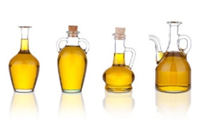 Cuatro jarras con aceite de ajonjolí en un fondo blanco