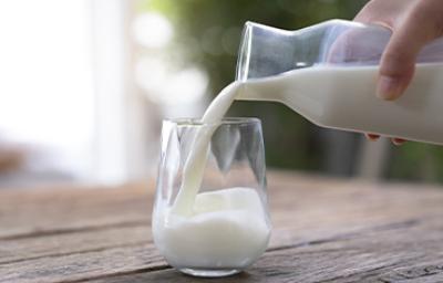 Jarra y vaso con un tipo de leche sobre una mesa de madera Jarra y vaso con un tipo de leche sobre una mesa de madera
