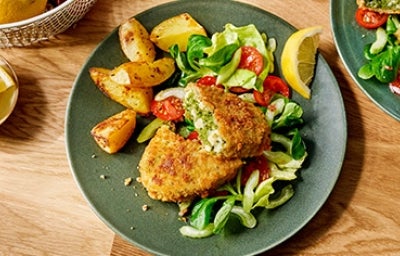 Pollo apanado relleno de apio, queso y espinaca con papas horneadas y ensalada, una receta deliciosa