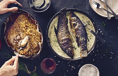 Dos bagres fritos en salsa en toma cenital sobre un fondo negro y acompañados de arroz amarillo Dos bagres fritos en salsa en toma cenital sobre un fondo negro y acompañados de arroz amarillo