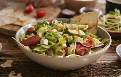 Ensalada mediterránea en una mesa con diferentes acompañamientos Ensalada mediterránea en una mesa con diferentes acompañamientos