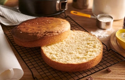 Bizcocho genovés abierto en capas sobre una red metálica negra Bizcocho genovés abierto en capas sobre una red metálica negra