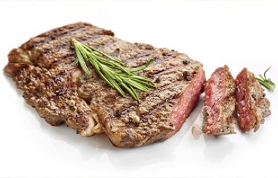 Corte de solomillo cocinado con una receta de hierbas, romero y condimentos sobre un fondo blanco Corte de solomillo cocinado con una receta de hierbas, romero y condimentos sobre un fondo blanco