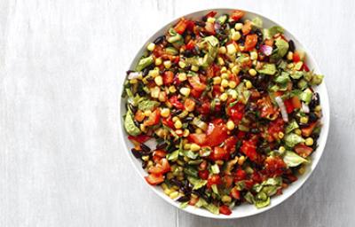 Una ensalada cremosa con maíz, tomate y aguacate en toma cenital Una ensalada cremosa con maíz, tomate y aguacate en toma cenital