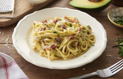 Pasta carbonara con pollo, tocineta y hierbas en un plato hondo Pasta carbonara con pollo, tocineta y hierbas en un plato hondo