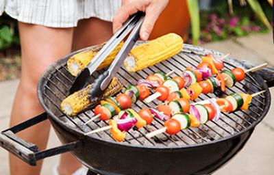 Asador con vegetales y pinzas de cocina