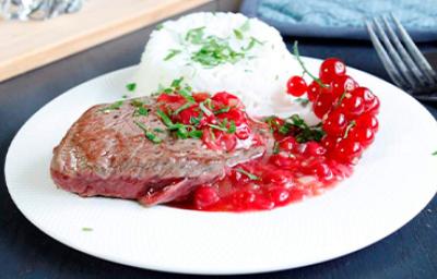 Plato de carne, arroz y salsa de grosellas Plato de carne, arroz y salsa de grosellas