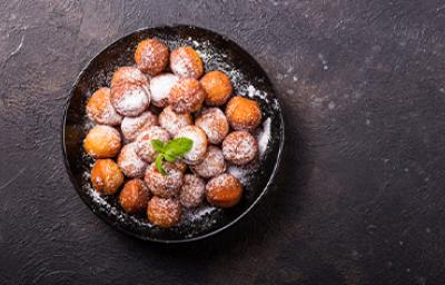 Plato de buñuelos de yuca espolvoreados vistos desde un ángulo cenital.