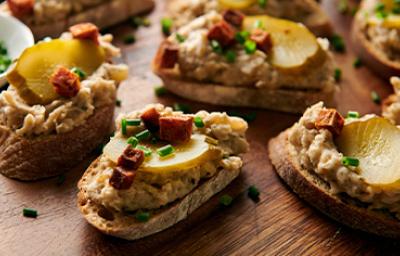 Montaditos de pan crujiente con pepinillos y chorizo