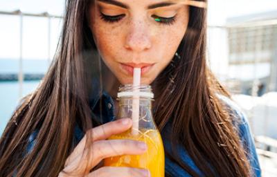 Mujer bebiendo un refrescante jugo de zanahoria con limón