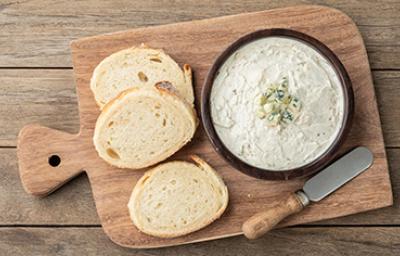 Tabla con rodajas de pan para esparcir salsa gorgonzola Tabla con rodajas de pan para esparcir salsa gorgonzola