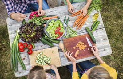 Familia preparando al aire libre ensalada de pulpo
